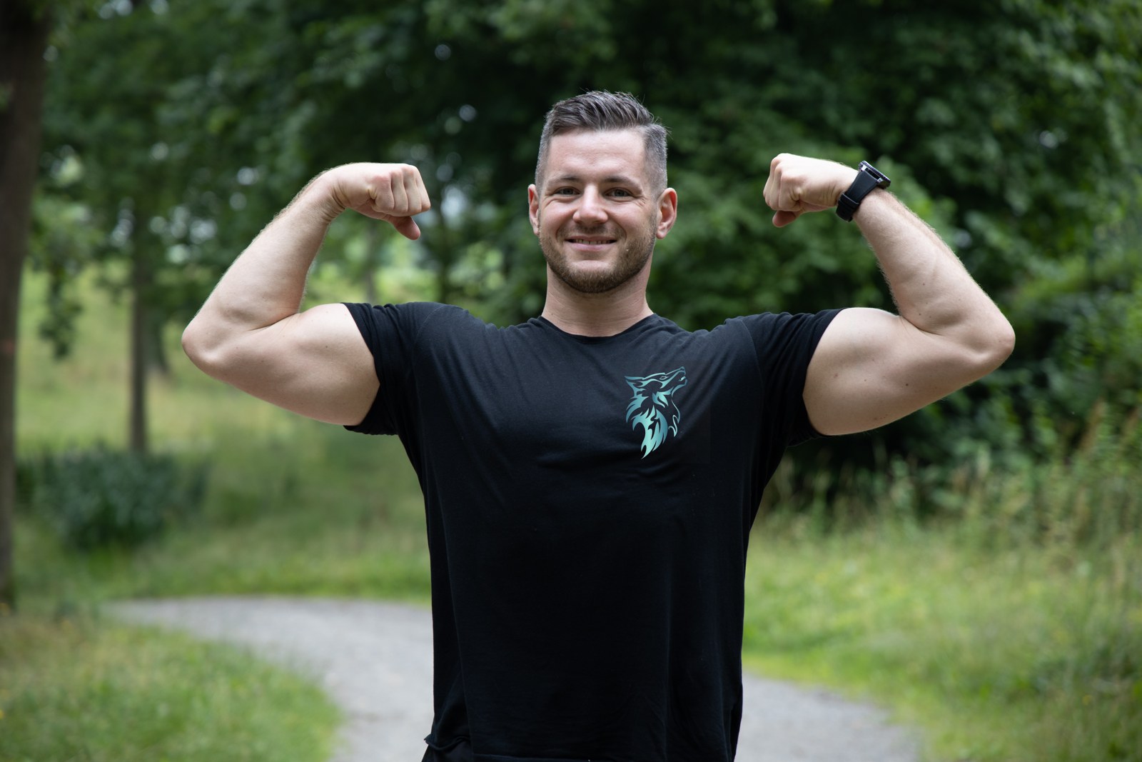der Fitnesswolf – Coach mit Wolf-Logo auf dem Shirt